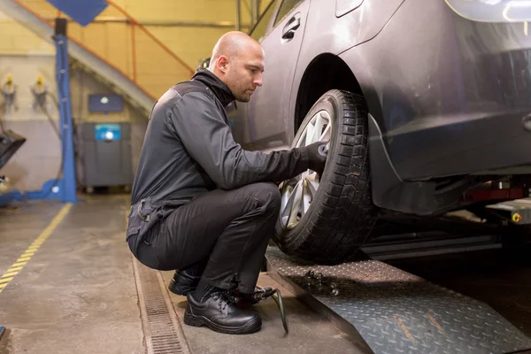 Mecánico automático cambiar el neumático del coche en el taller — Foto de Stock