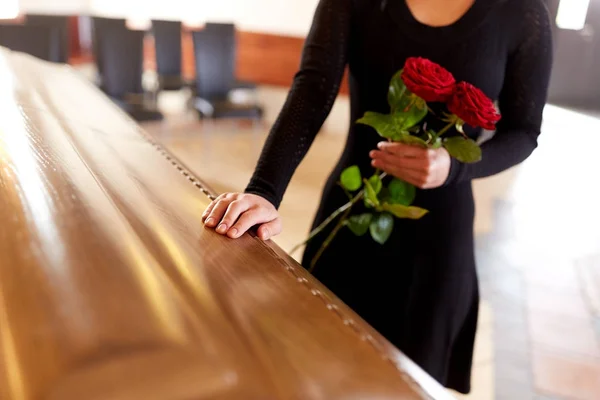 Kobieta z czerwonymi różami i trumna pogrzebowe — Zdjęcie stockowe