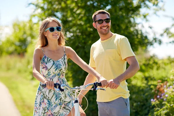 Coppia felice con bicicletta in campagna — Foto Stock