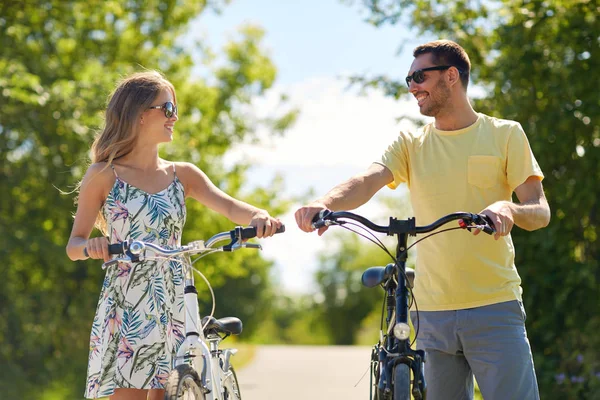 Lyckliga par med cyklar på landsväg — Stockfoto