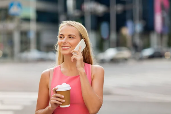 Woman with coffee calling on smartphone in city — Stock Photo, Image