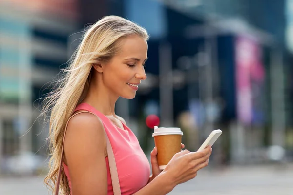 Žena s kávou a smartphone v městě — Stock fotografie