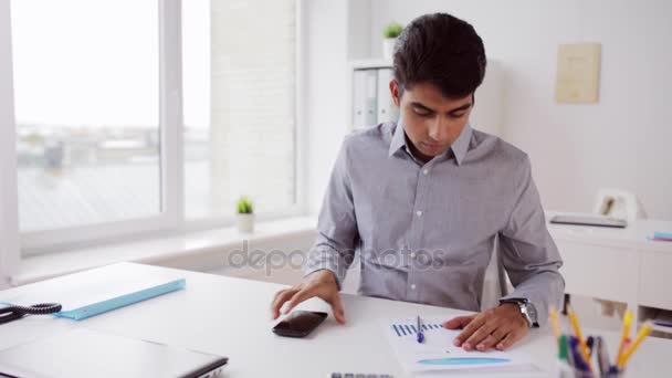 Businessman with smartphone and papers at office — Stock Video