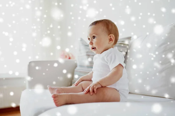 Menino ou menina feliz sentado no sofá em casa — Fotografia de Stock