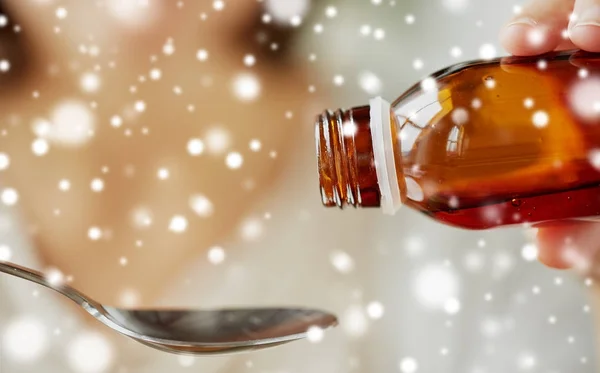 Woman pouring medication from bottle to spoon — Stock Photo, Image