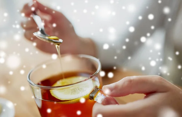 Крупним планом жінка додає мед до чаю з лимоном — стокове фото