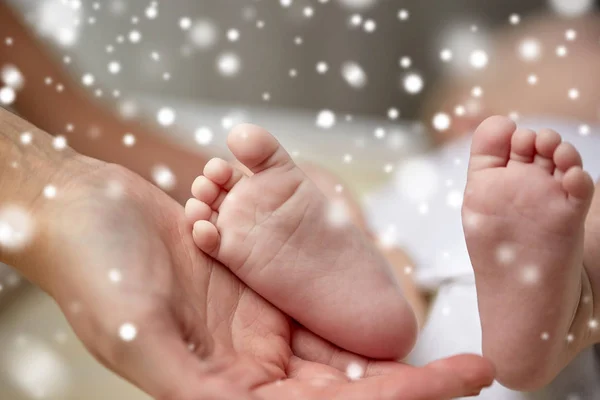 母の手で生まれたばかりの赤ちゃんの足のクローズ アップ — ストック写真