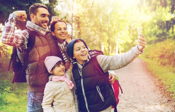 Familj med ryggsäckar med selfie av smartphone — Stockfoto