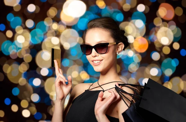 Mujer feliz con tarjeta de crédito y bolsas de compras — Foto de Stock