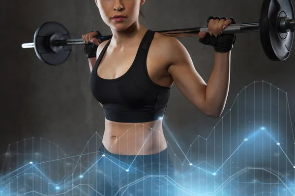 Jovem mulher flexionando músculos com barbell no ginásio — Fotografia de Stock