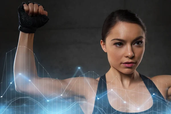 Ung kvinna flexar muskler i gymmet — Stockfoto