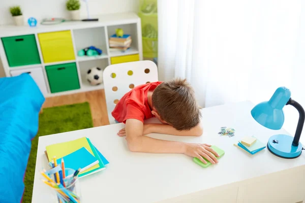 Niño estudiante cansado o triste con teléfono inteligente en casa —  Fotos de Stock