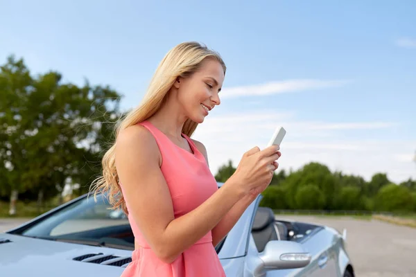 コンバーチブル車でスマート フォンを持つ若い女性 — ストック写真