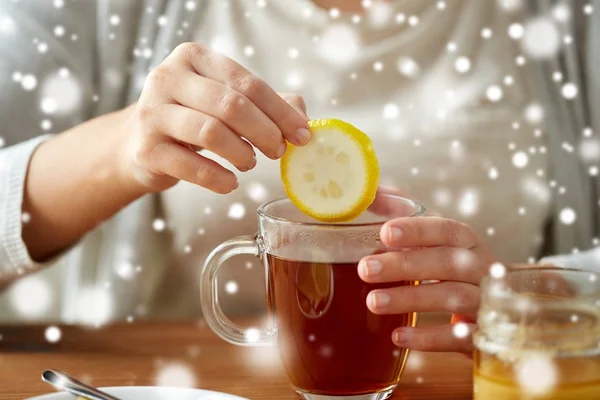 Крупним планом жінка додає лимон до чаю з медом — стокове фото