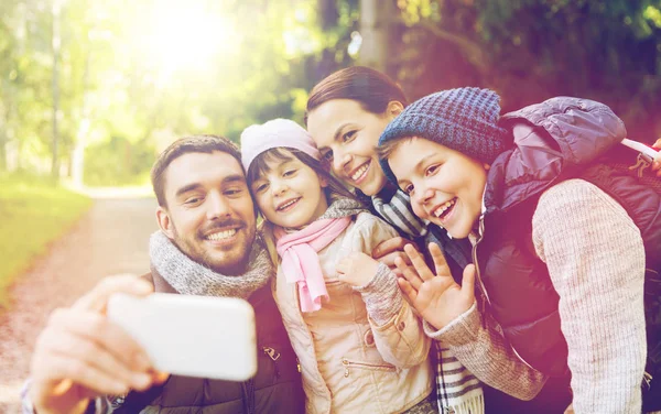 Rodina s batohy s selfie do smartphone — Stock fotografie