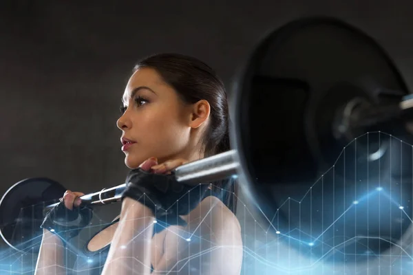 Ung kvinna flexar muskler med skivstång i gym — Stockfoto