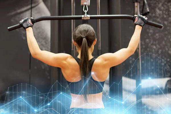 Žena, protahuje svaly na kabel stroj v tělocvičně — Stock fotografie