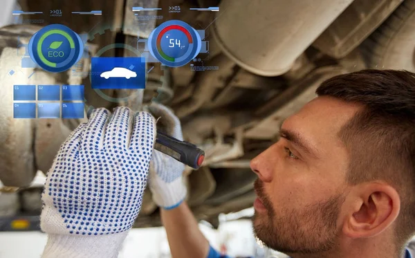 Mechaniker mit Taschenlampe repariert Auto im Geschäft — Stockfoto