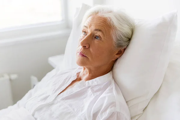 Triste anciana acostada en la cama en el hospital — Foto de Stock