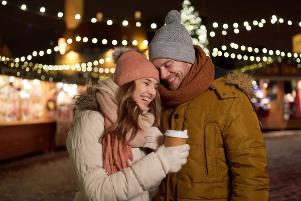 Heureux jeune couple avec café au marché de Noël — Photo