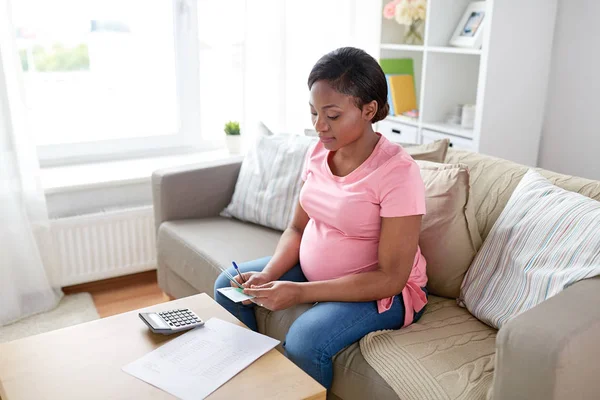 Happy pregnant woman counting money at home — Stock Photo, Image