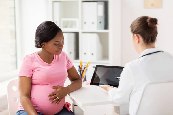 医生与片剂个人计算机和孕妇在诊所 — 图库照片