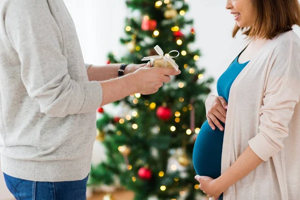 Marido dando regalo de Navidad a la esposa embarazada — Foto de Stock