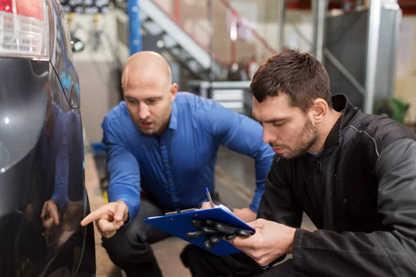 Automechaniker und Kunde schauen sich Auto an — Stockfoto