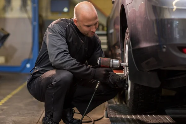 Automonteur met schroevendraaier auto band wijzigen — Stockfoto