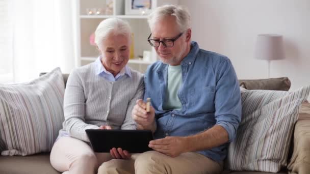 Счастливая пожилая пара с планшетным ПК и кредитной карты — стоковое видео
