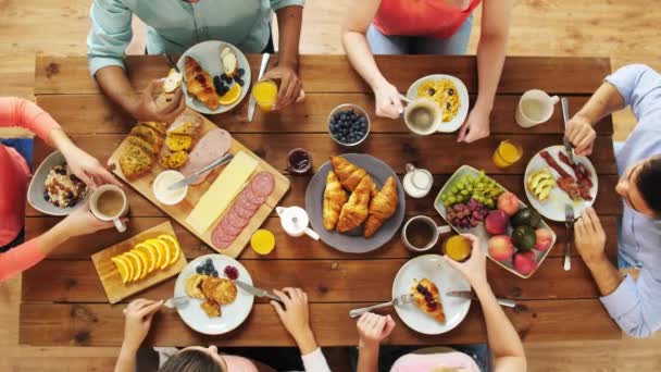 Grupo de personas que comen en la mesa con alimentos — Vídeo de stock