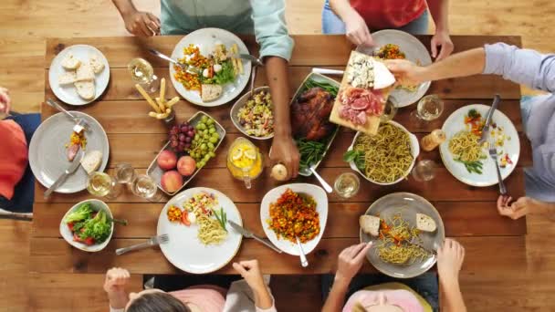 Grupo de personas que comen en la mesa con alimentos — Vídeo de stock