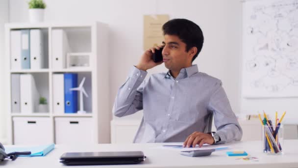 Hombre de negocios llamando en teléfono inteligente en la oficina — Vídeos de Stock