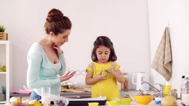 Mother and daughter cooking cupcakes at home — Stock Video