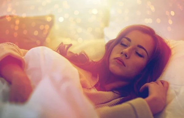 Молода жінка спить в ліжку вдома — стокове фото