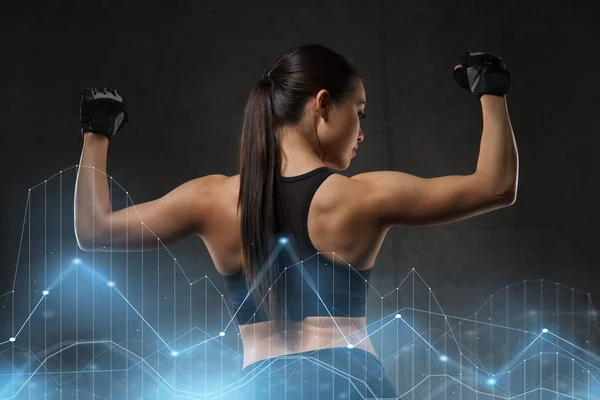 Mujer joven flexionar los músculos en el gimnasio — Foto de Stock