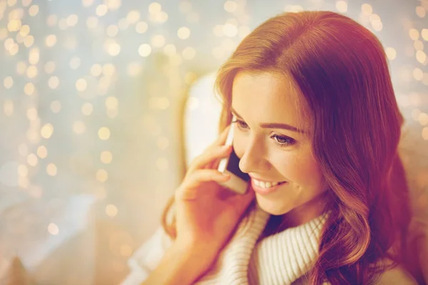 Feliz joven que llama en el teléfono inteligente en casa Imagen De Stock