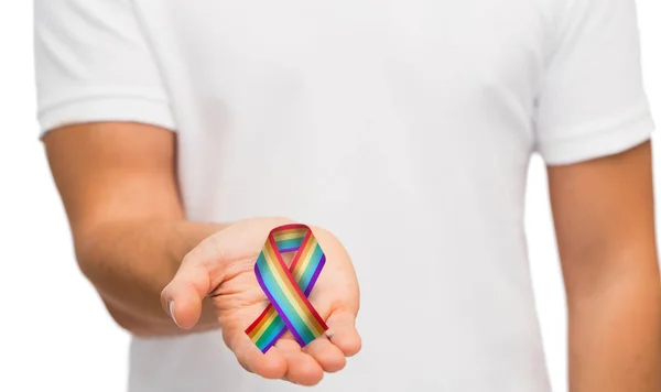 Manlig hand hållande gay pride awareness ribbon — Stockfoto