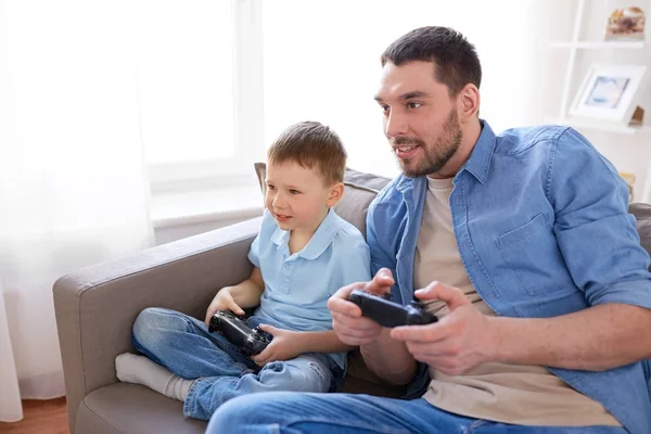 Pai e filho jogando videogame em casa — Fotografia de Stock