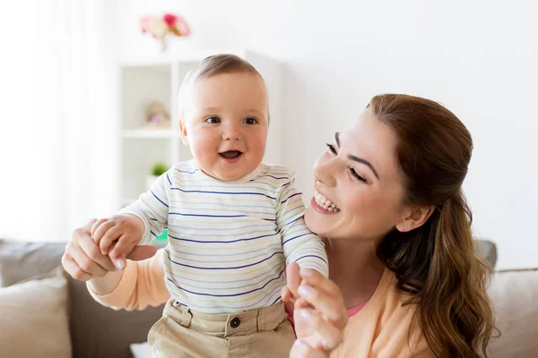 Feliz joven madre con pequeño bebé en casa —  Fotos de Stock