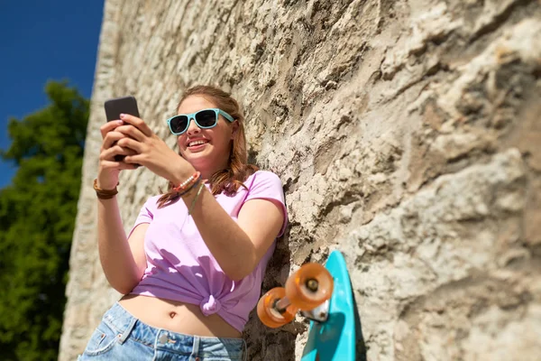 Adolescente feliz con longboard y smartphone — Foto de Stock