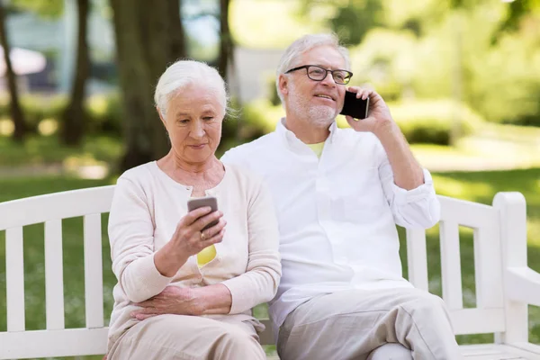 Gelukkige senior paar met smartphones bij park — Stockfoto