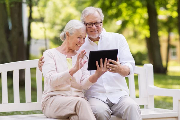 Pareja de ancianos con chat de vídeo en la tableta de PC en el parque —  Fotos de Stock