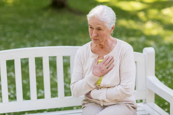 Старшая женщина чувствует себя больной в летнем парке — стоковое фото