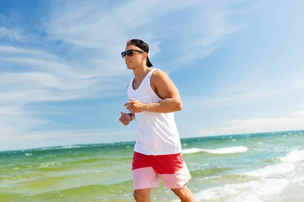 Homme heureux courant le long de la plage d'été — Photo