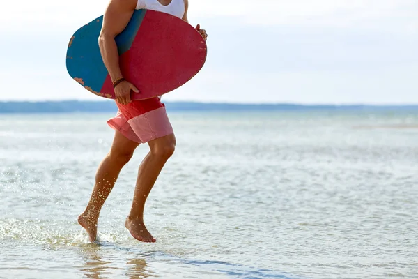 Young man with skimboard on summer beach — Stock Photo, Image