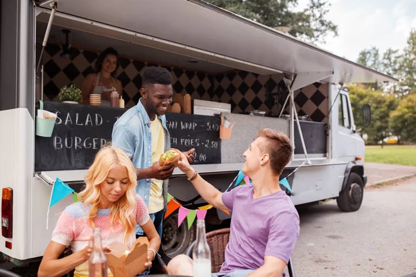 Happy přátelé s nápoji jíst v kamionu potravin — Stock fotografie