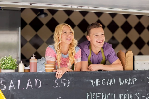 Heureux jeunes vendeurs au camion alimentaire — Photo