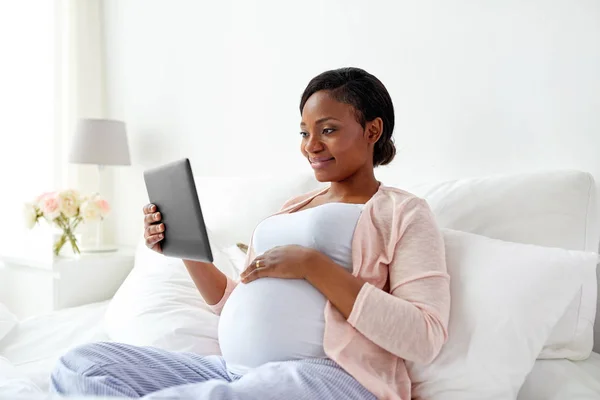 Mujer embarazada feliz con la tableta PC en casa — Foto de Stock