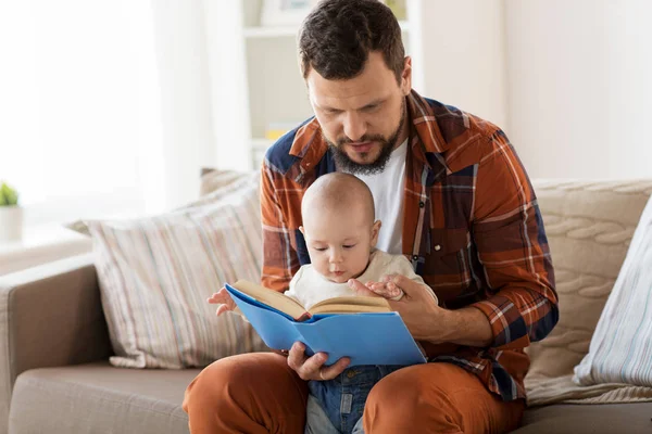 Heureux père et petit garçon avec livre à la maison — Photo